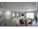 Open-concept living and dining area featuring wood floors, modern light fixtures, and large windows for natural light at 14308 Abington Heights Dr, Orlando, FL 32828