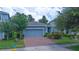 Attractive blue home boasting a brick driveway, manicured landscaping, and a two-car garage at 1529 Chelsea Manor Cir, Deland, FL 32724