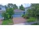 Beautiful blue home with a brick driveway, lush landscaping, and a two-car garage at 1529 Chelsea Manor Cir, Deland, FL 32724