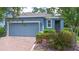 Charming single-story home with a brick driveway, lush landscaping, and a welcoming blue exterior at 1529 Chelsea Manor Cir, Deland, FL 32724