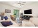Bright living room features stylish furniture, ceiling fan, and sliding glass doors to the outdoors at 1529 Chelsea Manor Cir, Deland, FL 32724