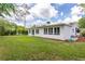 The home's backyard features a manicured lawn and white exterior at 1801 Palm Ln, Orlando, FL 32803