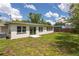 View of the home's backyard, with lush green grass and a sliding glass door at 1801 Palm Ln, Orlando, FL 32803