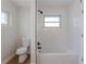 Bathroom featuring a white bathtub and shower combination with white tile and modern fixtures at 1801 Palm Ln, Orlando, FL 32803