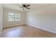 Bright bedroom featuring a ceiling fan, wood-look flooring, and a window at 1801 Palm Ln, Orlando, FL 32803