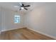 Bright bedroom featuring a ceiling fan, wood-look flooring, and a window at 1801 Palm Ln, Orlando, FL 32803