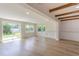 Living room with wooden beams, light wood floors, and sliding door to exterior at 1801 Palm Ln, Orlando, FL 32803