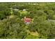 Aerial view of a secluded home nestled among lush trees, showcasing a private pool and expansive green space at 1815 Big Oak Ln, Kissimmee, FL 34746