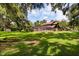 Expansive backyard featuring a screened-in pool area, mature trees, and a well-maintained lawn at 1815 Big Oak Ln, Kissimmee, FL 34746