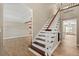 Entryway with wood-look floors, white and wood staircase and high ceilings at 1815 Big Oak Ln, Kissimmee, FL 34746