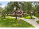 Sprawling property featuring a long driveway, lush landscaping, and mature trees at 1815 Big Oak Ln, Kissimmee, FL 34746