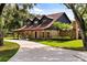 Brick home featuring dormer windows, long driveway, and manicured front lawn at 1815 Big Oak Ln, Kissimmee, FL 34746