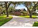Charming two-story home featuring mature trees, a large circular driveway, and well-manicured landscaping at 1815 Big Oak Ln, Kissimmee, FL 34746