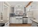 Bright kitchen features farmhouse sink, updated cabinetry, blue backsplash, and stainless steel dishwasher at 1815 Big Oak Ln, Kissimmee, FL 34746