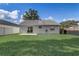 Spacious backyard featuring a well-kept lawn, a patio area, and full fencing ensuring privacy and space for outdoor activities at 1821 Geigel Ave, Orlando, FL 32806