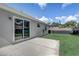 Well-manicured backyard with a concrete patio and expansive green space, enhanced by a sliding glass door at 1821 Geigel Ave, Orlando, FL 32806