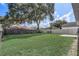 Grassy backyard with a patio, framed by mature trees and a fence, creates a private outdoor retreat at 1821 Geigel Ave, Orlando, FL 32806