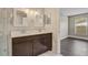Bright bathroom featuring a double sink vanity with dark wood cabinets and neutral-toned walls and a walk-in shower at 1821 Geigel Ave, Orlando, FL 32806