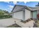 A gray house with a white garage door, some foliage, and a side front entrance at 1821 Geigel Ave, Orlando, FL 32806