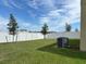 Large backyard with privacy fence, green grass, and an AC unit to the side at 1855 Church Lake St, Groveland, FL 34736