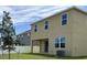 Tan two-story home featuring white framed windows and a covered patio in the backyard at 1855 Church Lake St, Groveland, FL 34736