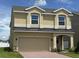 Inviting two-story home featuring a two-car garage, arched entry, tan stucco, and a well-maintained lawn at 1855 Church Lake St, Groveland, FL 34736