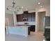 Bright kitchen with stainless steel appliances, an island with bar seating, and dark brown cabinets at 1855 Church Lake St, Groveland, FL 34736