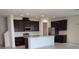 Open-concept kitchen with stainless steel appliances, a central island, granite countertops, and dark wood cabinets at 1855 Church Lake St, Groveland, FL 34736