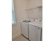 Functional laundry room with modern washer and dryer, tile flooring, a wire shelf, and a window at 1855 Church Lake St, Groveland, FL 34736