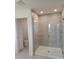 Bathroom shower with gray tile, glass door, and chrome shower head at 1855 Church Lake St, Groveland, FL 34736