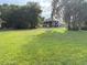 Large backyard with green grass and shady trees provides ample space for outdoor activities at 1865 S Tanner Ct, Deltona, FL 32738
