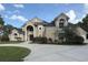 Stately tan home boasting an elegant entrance, arched windows, and lush landscaping at 1865 S Tanner Ct, Deltona, FL 32738