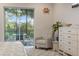 Comfortable bedroom featuring a cozy sitting area, screened-in porch view, and ample natural light for relaxation at 1962 Flora Pass Pl, Kissimmee, FL 34747