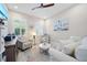 Cozy living room featuring comfortable seating, a ceiling fan, and coastal-themed artwork at 1962 Flora Pass Pl, Kissimmee, FL 34747