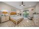 Serene main bedroom with a ceiling fan, ensuite bathroom, and a sliding glass door to a lanai at 1962 Flora Pass Pl, Kissimmee, FL 34747