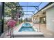 Inviting in-ground pool and spa area with a screened enclosure and lounging space for outdoor enjoyment at 1962 Flora Pass Pl, Kissimmee, FL 34747