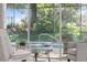 View of the screened lanai with pool area surrounded by mature trees, as seen from inside the home at 1962 Flora Pass Pl, Kissimmee, FL 34747