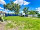 Large, grassy backyard, featuring a fenced area and mature trees for privacy at 207 Kay St, Auburndale, FL 33823