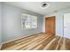 Bedroom features hardwood floors, a window with blinds and a wooden closet at 207 Kay St, Auburndale, FL 33823