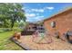 Spacious backyard featuring a playset, gravel area, and patio space, surrounded by mature trees and landscaping at 209 Carriage Hill Dr, Casselberry, FL 32707