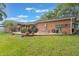 Expansive backyard with a well-maintained lawn, playset, patio area, and lush greenery, perfect for outdoor enjoyment at 209 Carriage Hill Dr, Casselberry, FL 32707