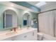 Stylish bathroom featuring double vanity, arched mirrors, and combination tub and shower at 209 Carriage Hill Dr, Casselberry, FL 32707
