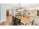 Open dining room featuring hardwood floors, modern lighting, bar area, and easy access to the kitchen at 209 Carriage Hill Dr, Casselberry, FL 32707