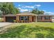 Charming brick home featuring a well-manicured lawn and attached garage at 209 Carriage Hill Dr, Casselberry, FL 32707