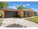Charming single-story brick home featuring an attached two-car garage and well-maintained lawn with mature landscaping at 209 Carriage Hill Dr, Casselberry, FL 32707