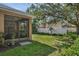 Backyard featuring a screened-in porch, lush lawn, and a privacy fence at 215 Foxglove Way, Deland, FL 32724
