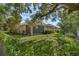 Spacious backyard showcasing a screened-in porch, verdant lawn, and mature trees at 215 Foxglove Way, Deland, FL 32724