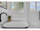 Modern bathroom featuring a soaking tub, white subway tile, and large window at 215 Foxglove Way, Deland, FL 32724