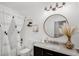 Well-lit bathroom with modern fixtures, updated lighting, floating shelves, shower and vanity at 215 Foxglove Way, Deland, FL 32724