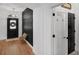 Modern entryway with wood floors, unique wall decor, and stylish black doors at 215 Foxglove Way, Deland, FL 32724